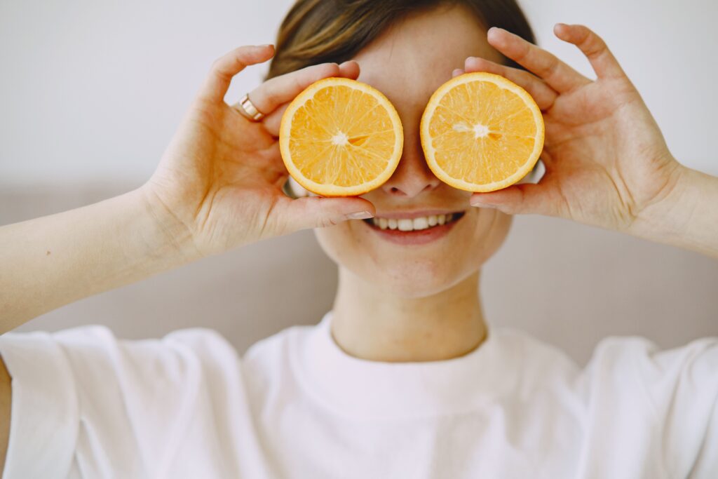 pexels photo 4148925 4148925 Crop positive female covering eyes with fresh slices of orange smiling and looking forward on blurred background